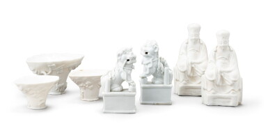 View full screen - View 1 of Lot 152. Two blanc de Chine figures of lion dogs and three blanc de Chine libation cups, Qing dynasty, 17th-18th century | 清十七至十八世紀 德化白瓷佛獅、盃及 白瓷人物坐像 一組七件.