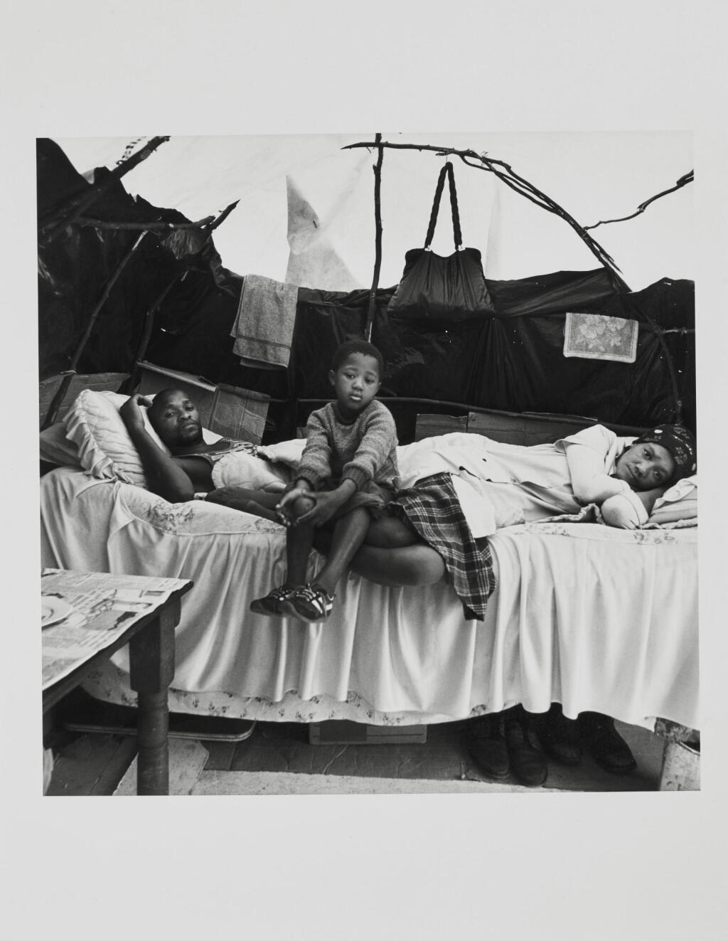 View full screen - View 1 of Lot 98. DAVID GOLDBLATT | A FAMILY IN THEIR SHELTER AT KTC SQUATTER CAMP, CAPE TOWN, 1984 .