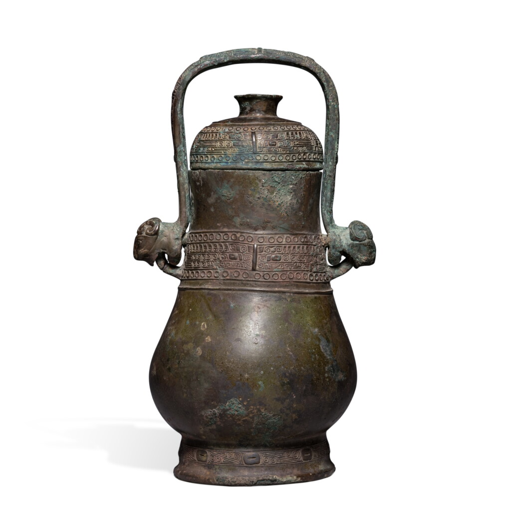 View full screen - View 1 of Lot 617. An archaic bronze ritual wine vessel and cover (Hu), Late Shang / early Western Zhou dynasty | 商末 / 西周初 青銅饕餮紋提梁壺.