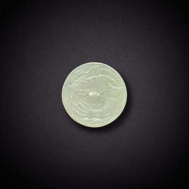 View full screen - View 1 of Lot 3527. A white jade 'makara' 'mirror' ornament, Liao dynasty | 遼 白玉龍魚紋鏡形飾.