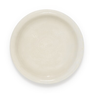 View full screen - View 1 of Lot 73. A large incised 'Dehua' dish, Qing dynasty, 17th century | 清十七世紀 德化白釉刻花卉紋盤.