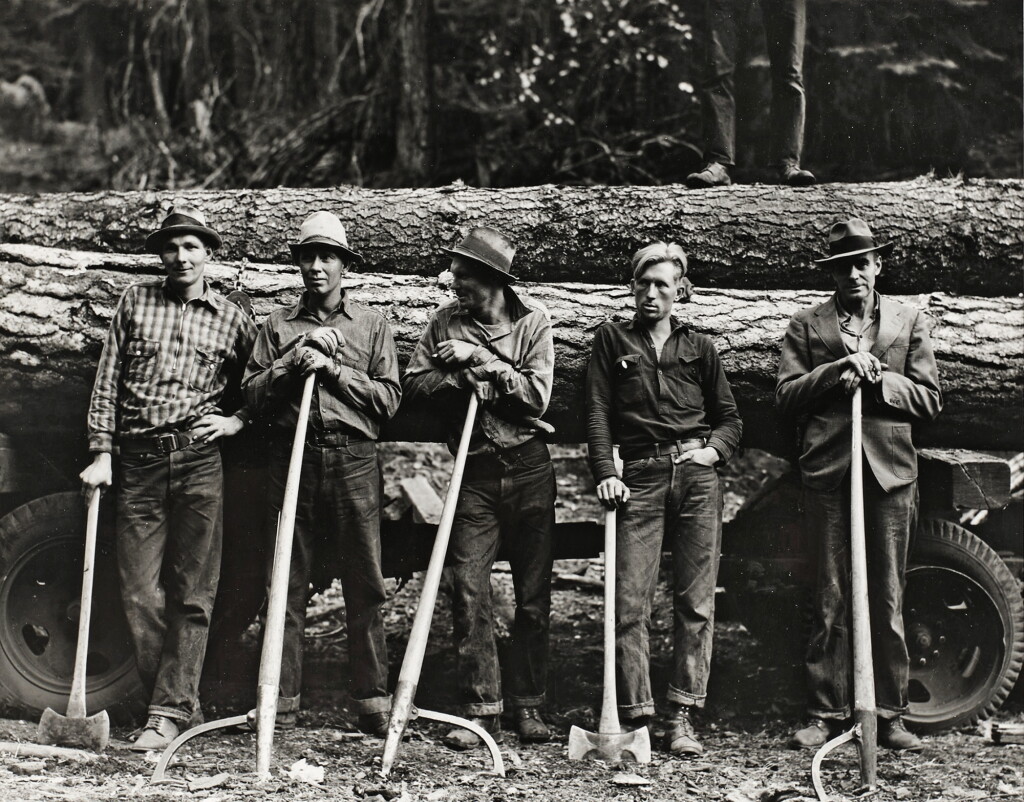 View full screen - View 1 of Lot 323. 5 Idaho farmers, members of the Ola Self Help Sawmill Co-op, in the woods standing against load of logs ready to go down to their mill about three miles away. Gem County, Idaho.