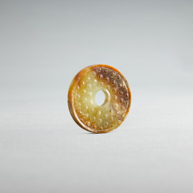 View full screen - View 1 of Lot 734. A small pale-celadon jade disc, bi, Eastern Zhou dynasty, Spring and Autumn period | 東周春秋 青白玉榖紋璧.