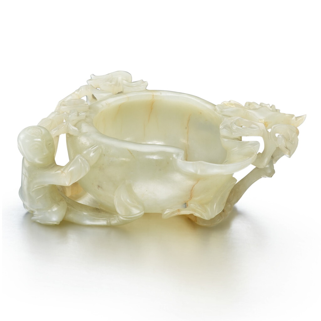 View full screen - View 1 of Lot 36. A celadon jade 'boy' pouring vessel, Ming dynasty | 明 青玉雕榴開百子洗.