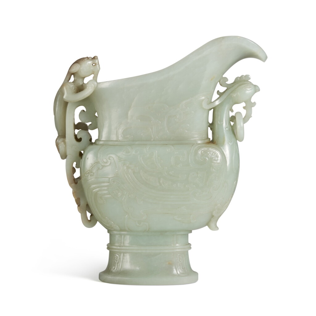 View full screen - View 1 of Lot 82. A large pale green jade archaistic phoenix-form vessel (Guang), Qing dynasty, Qianlong period | 清乾隆 青玉仿古鳳首螭龍紋觥.