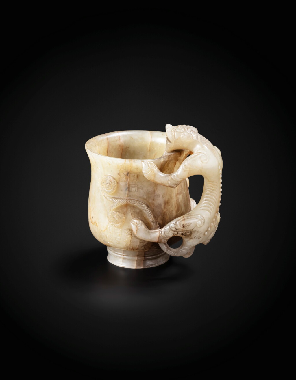 View full screen - View 1 of Lot 32. A well carved Ming-style inscribed archaistic 'chilong' cup Qing dynasty, 18th-19th century | 清十八至十九世紀 青白玉仿明鏤雕螭龍耳盃.