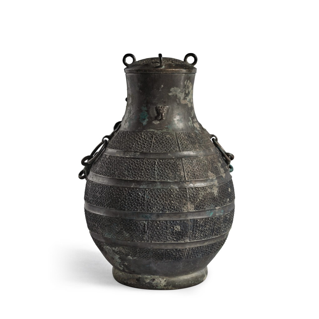 View full screen - View 1 of Lot 247. An archaic bronze wine vessel and cover (Hu), Eastern Zhou dynasty, Warring States period | 東周 戰國 青銅交龍紋牛首耳蓋壺.