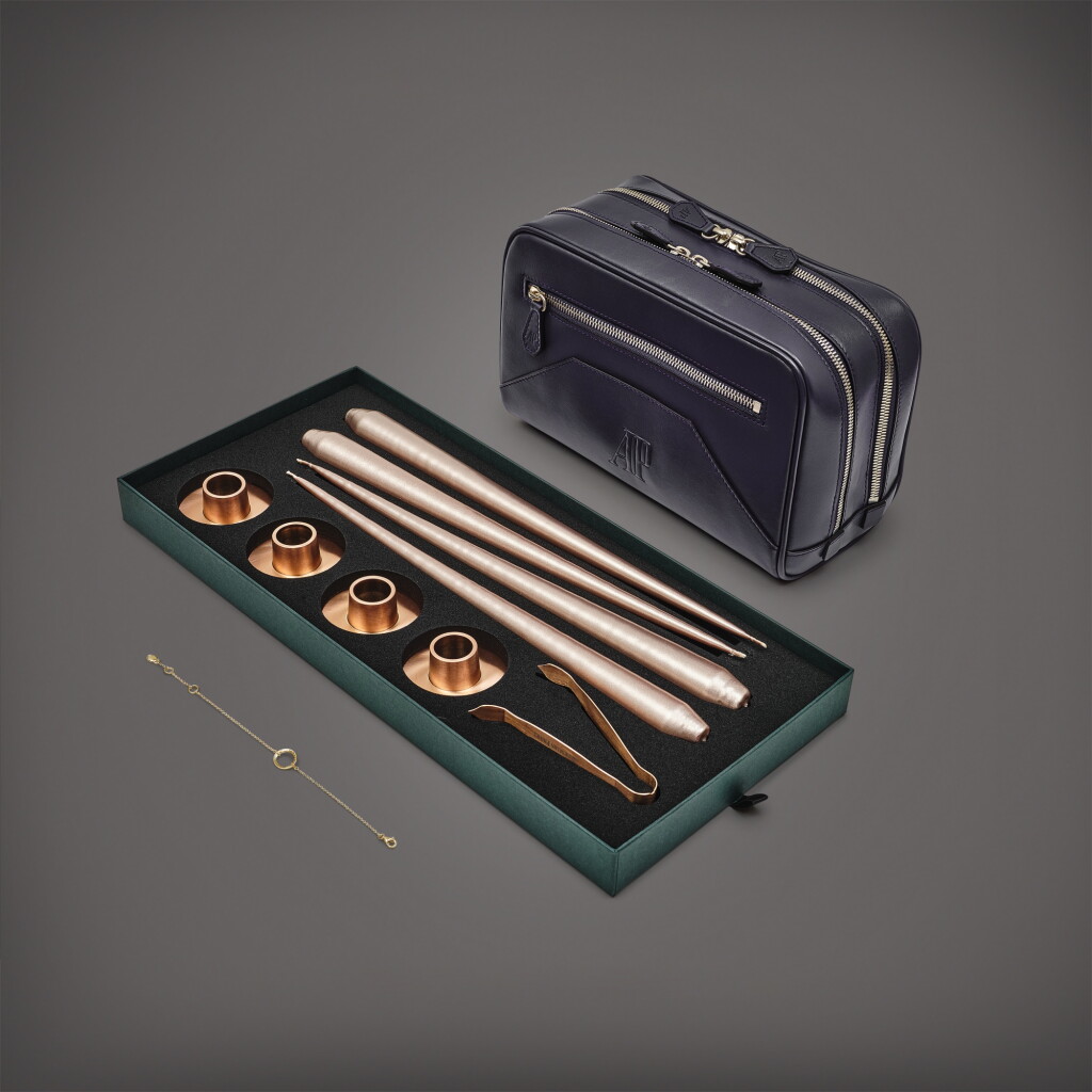 View full screen - View 1 of Lot 8699. A set of four Christmas candles, gold-plated silver Millenary bracelet and leather clutch bag, Circa 2021 | 愛彼 | 一套四件聖誕蠟燭、鍍金銀製千禧系列手鐲及皮製手提包,約2021年製.