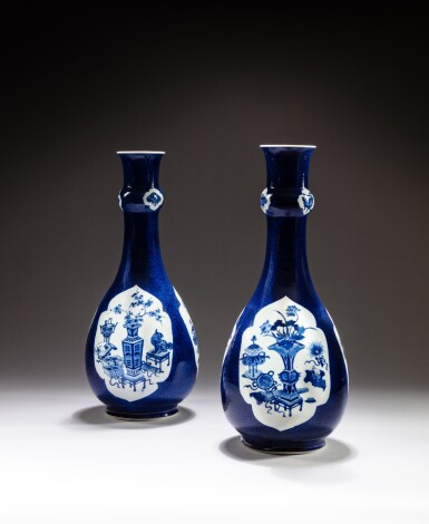 View full screen - View 1 of Lot 130. Two large powder-blue ground blue and white ‘hundred antiques’ bottle vases, Qing dynasty, Kangxi period | 清康熙 灑藍地開光青花博古圖長頸瓶一組兩件.