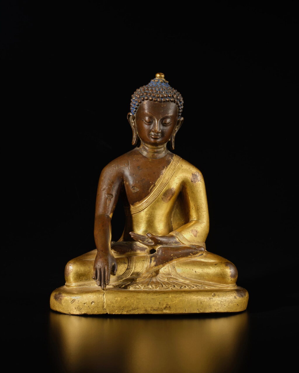 View full screen - View 1 of Lot 138. A parcel-gilt copper alloy figure of Shakyamuni Buddha, Nepal, circa 18th century | 尼泊爾 約十八世紀 銅合金局部鎏金釋迦牟尼佛坐像.