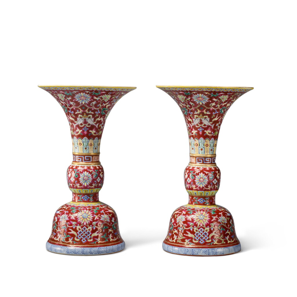 View full screen - View 1 of Lot 270. A pair of ruby-ground famille-rose 'Eight Buddhist Emblems' altar vases (Gu), Seal marks and period of Qianlong | 清乾隆 胭脂紅地粉彩纏枝蓮八吉祥紋花觚一對 《大清乾隆年製》款.