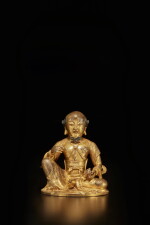 A small gilt copper alloy seated figure of a luohan, Qing dynasty, 18th century