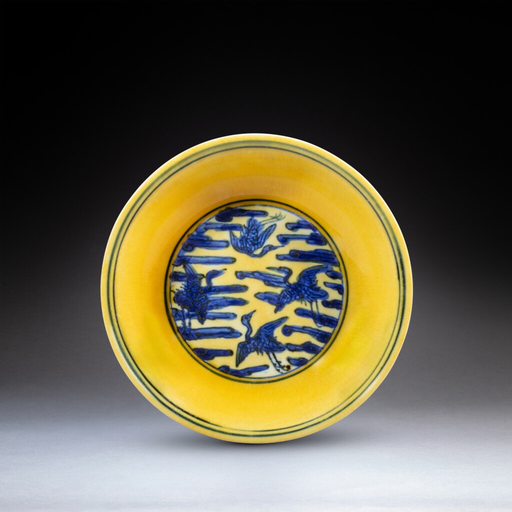 View full screen - View 1 of Lot 132. A yellow-ground underglaze-blue 'crane' dish, Mark and period of Jiajing | 明嘉靖 黃地青花雲鶴紋盤 《大明嘉靖年製》款 .