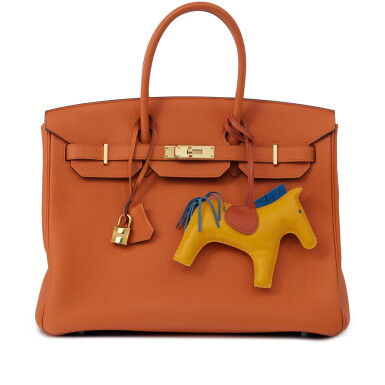 View full screen - View 1 of Lot 87. Orange H Togo Birkin 35 Gold Hardware, 2017 and Jaune d'Or, Bleu Agathe and Cornaline Swift Rodeo Charm.