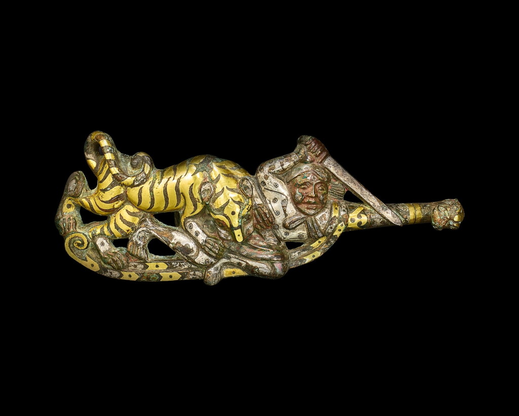 View full screen - View 1 of Lot 3603. A rare gold and silver-inlaid bronze 'warrior and tiger' garment hook, Western Han dynasty, 3rd - 2nd century BC | 西漢 公元前三至二世紀 銅錯金銀虎搏人紋帶鉤.