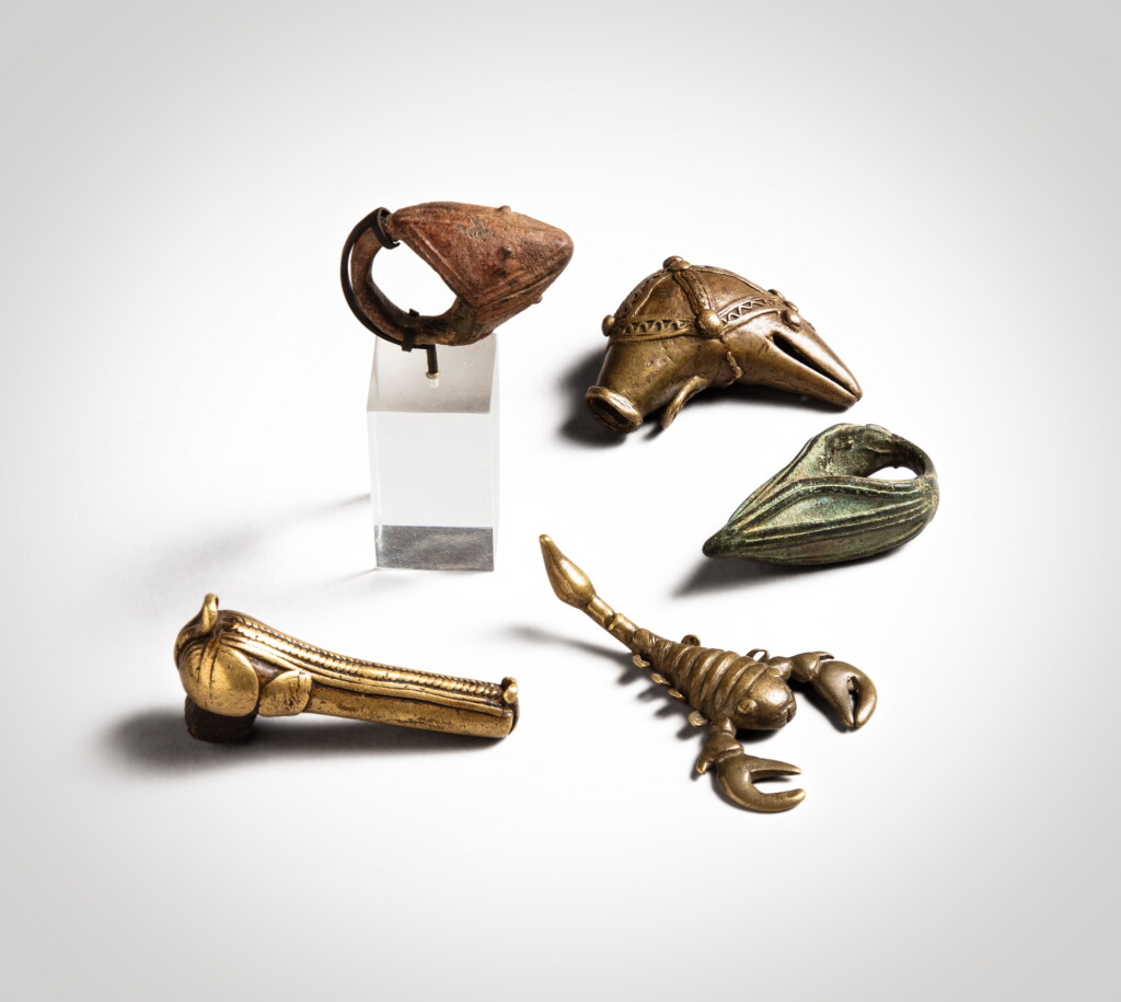 View full screen - View 1 of Lot 184. Ensemble de cinq objets comprenant deux deux bagues, une Djenné et une Léré, Mali, un pendentif, Dan, Côte d'Ivoire, un pommeau de sceptre en forme de tête de cheval et un poids à peser l'or en forme de scorpion, Akan, Ghana | Group of fove objects comprising two Rings, one Djenné and one Léré, Mali, a Pendant, Dan, Côte d'Ivoire, a Horse Head Scepter Pommel and a Scorpion Gold Weight, Akan, Ghana.