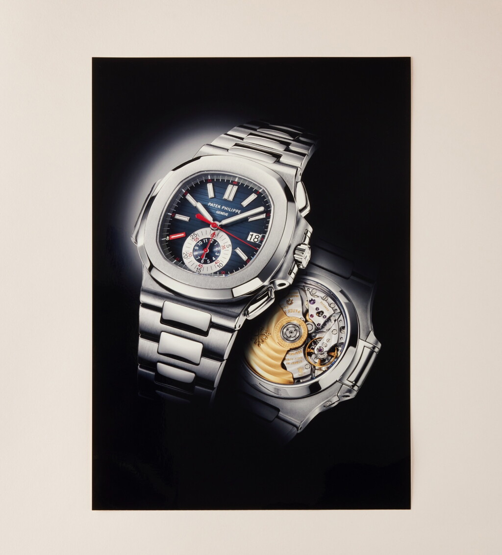 View full screen - View 1 of Lot 2314. Nautilus “Red Eight”, Reference 5980 | A possibly unique stainless steel flyback chronograph bracelet watch with date and red dial accents, In double factory seal, Circa 2009.