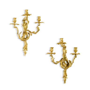 View full screen - View 1 of Lot 43. A pair of Louis XV style gilt-bronze three-light wall appliques, late 19th century, in the manner of Jacques Caffiéri.