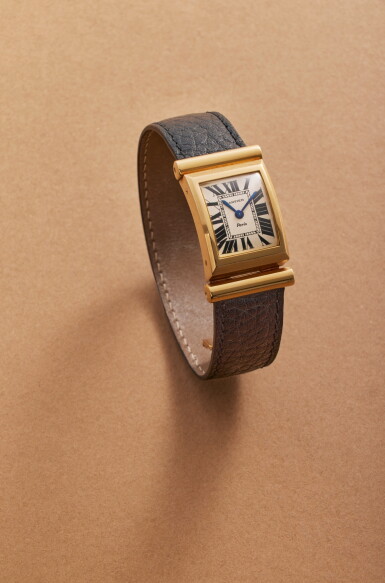 View full screen - View 1 of Lot 112. Driver | New York retailed: An unusual yellow gold deeply curved rectangular driver’s rear-wound wristwatch with integrated gold deployant buckle and Paris dial, Circa 1973.