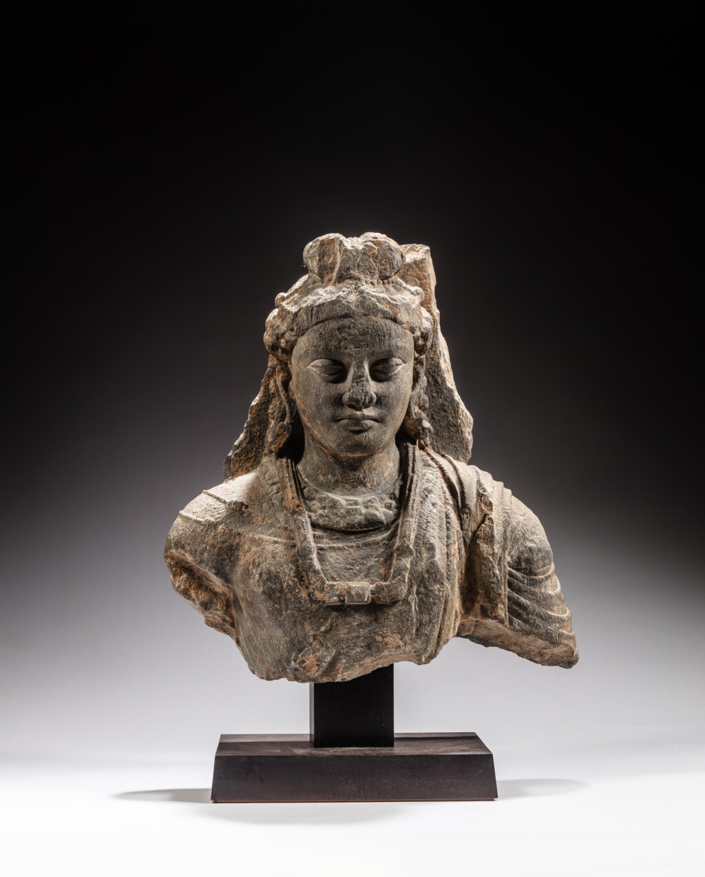 View full screen - View 1 of Lot 105. A large gray schist bust of a Bodhisattva, Ancient region of Gandhara, 3rd / 4th century | 犍陀羅 三 / 四世紀 灰片岩雕菩薩半身像.