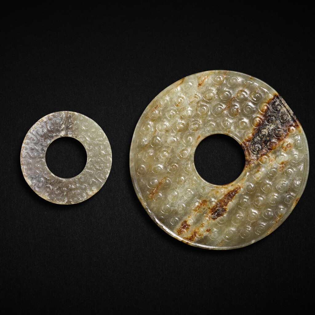 View full screen - View 1 of Lot 540. A pale celadon jade disc, bi, and a small greyish white jade ring, huan, Eastern Zhou dynasty, Warring States period | 東周戰國 青玉榖紋璧及灰白玉雲紋環.