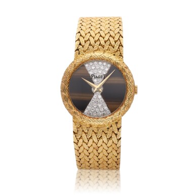 View full screen - View 1 of Lot 364. Reference 9040 | A yellow gold bracelet watch with diamond-set and tiger's eye dial, Circa 1980.