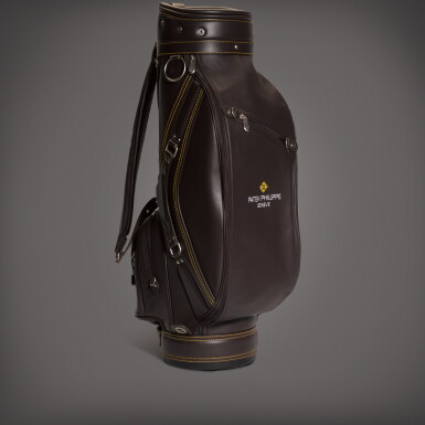 View full screen - View 1 of Lot 91. A brown leather golf bag with a towel | Circa 2018.