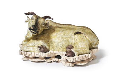 View full screen - View 1 of Lot 47. A porcelain figure of a reclining ox Qing Dynasty, Kangxi period, circa 1700-1722 | Figure de bœuf couché en porcelaine Chine, fin de l'époque Kangxi, entre 1700-1722.