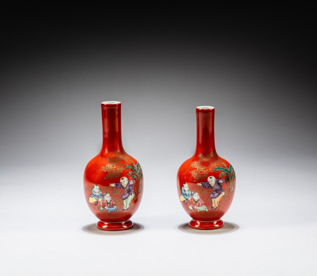 View full screen - View 1 of Lot 56. A pair of inscribed gilt-decorated coral-red-ground famille-rose 'boys at play' bottle vases, Marks and period of Guangxu | 清光緒 珊瑚紅地描金開光庭院嬰戲圖長頸瓶一對 《光緒年製》款.