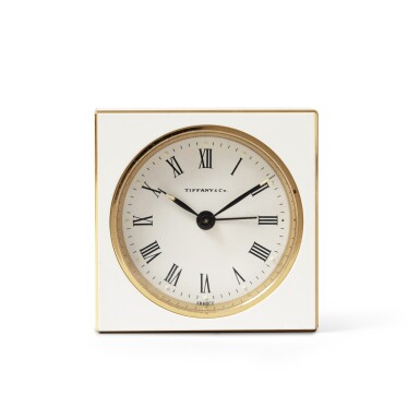 View full screen - View 1 of Lot 370. Tiffany & Co, New York A modern gilt brass and white enamel alarm travelling time piece | Ein moderner Wecker aus Messing und weißem Lack, nummeriert 71-1-424, Uhrwerk nicht funktionstüchtig.