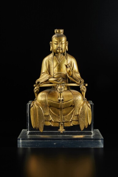View full screen - View 1 of Lot 252. A rare inscribed gilt-bronze figure of Yuanshi Taizun, by Chen Yanqing, Ming dynasty, early 15th century | 明十五世紀初 銅鎏金元始天尊坐像 《錢塘陳彥清造》款.