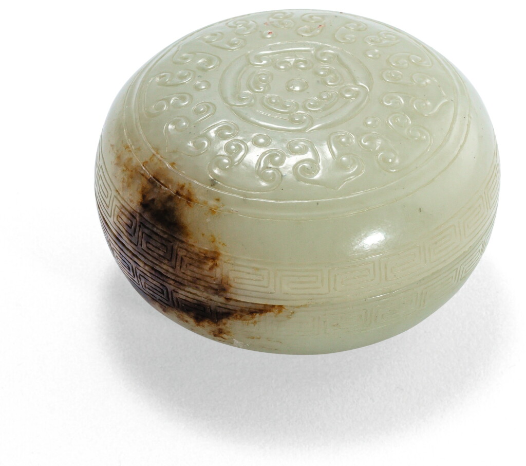 View full screen - View 1 of Lot 30. BOÎTE COUVERTE CIRCULAIRE EN JADE CÉLADON PÂLE ET ROUILLE DYNASTIE QING | 清 青白玉如意紋圓蓋盒 | A pale celadon and russet jade circular box and cover, Qing Dynasty.