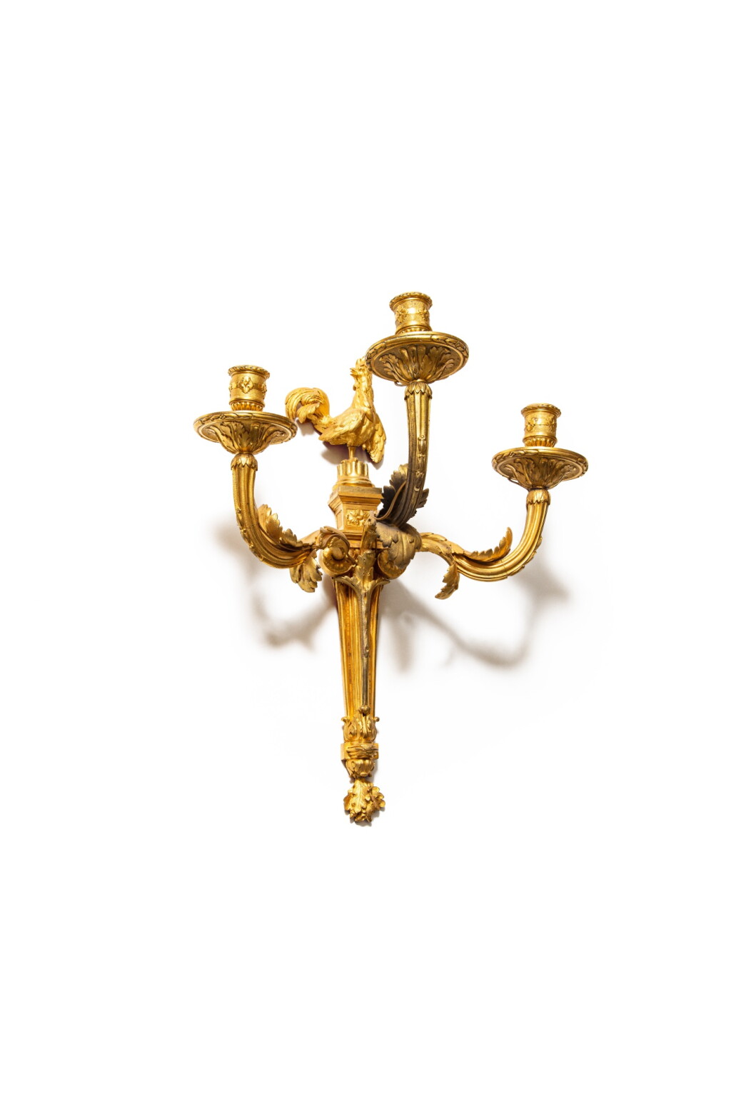 View full screen - View 1 of Lot 36. A late Louis XV gilt-bronze three-light wall lights, circa 1770, the model attributed to Jean-Louis Prieur | Paire d'appliques au coq en bronze doré de la fin de l'époque Louis XV, vers 1770, le modèle attribué à Jean-Louis Prieur.