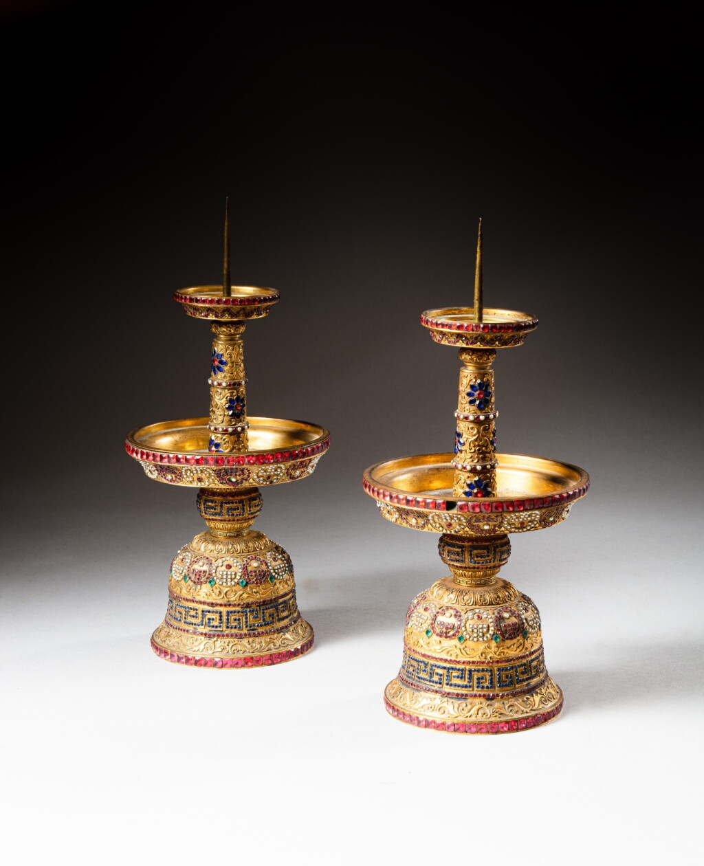 View full screen - View 1 of Lot 62. A pair of gilt-bronze and coloured pastes embellished candlesticks, Qing dynasty, Qianlong period | 清乾隆 鎏金銅嵌寳燭臺一對.