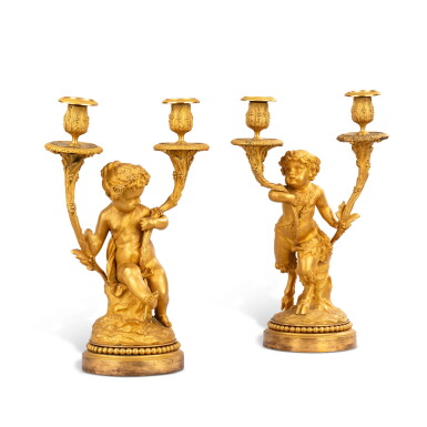 View full screen - View 1 of Lot 1043. A pair of Louis XVI style gilt-bronze two-lights candelabra, 19th century, after a model by Clodion | Paire de flambeaux en bronze doré de style Louis XVI, XIXe siècle, d'après un modèle de Clodion.