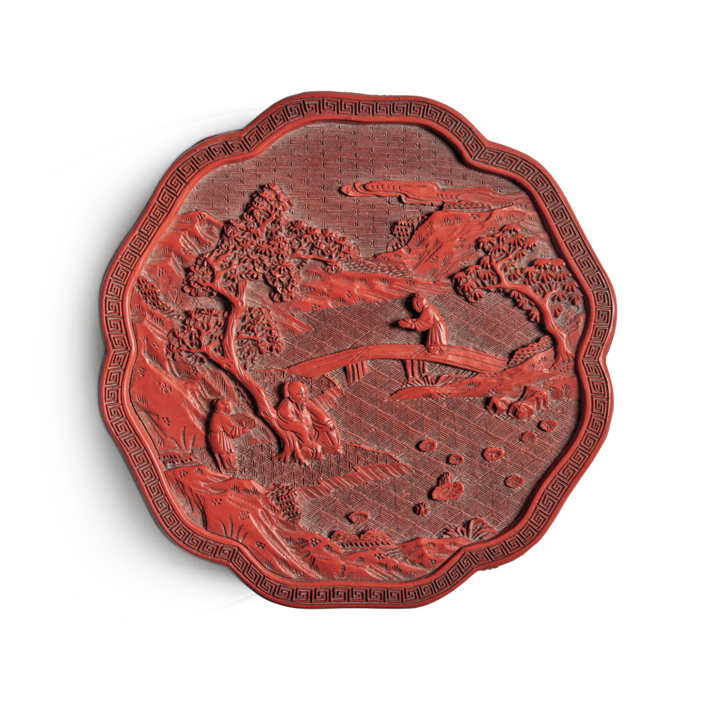 View full screen - View 1 of Lot 1313. A carved cinnabar lacquer lobed 'figural' box and cover, Qing dynasty, Qianlong period | 清乾隆 剔紅松下高士圖葵式蓋盒.