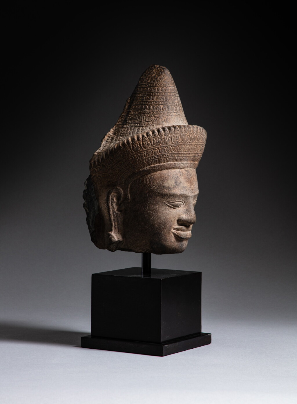 View full screen - View 1 of Lot 152. A sandstone head of a male deity, Khmer, Angkor, 12th century | 高棉 吳哥王朝十二世紀 砂岩石雕神首.