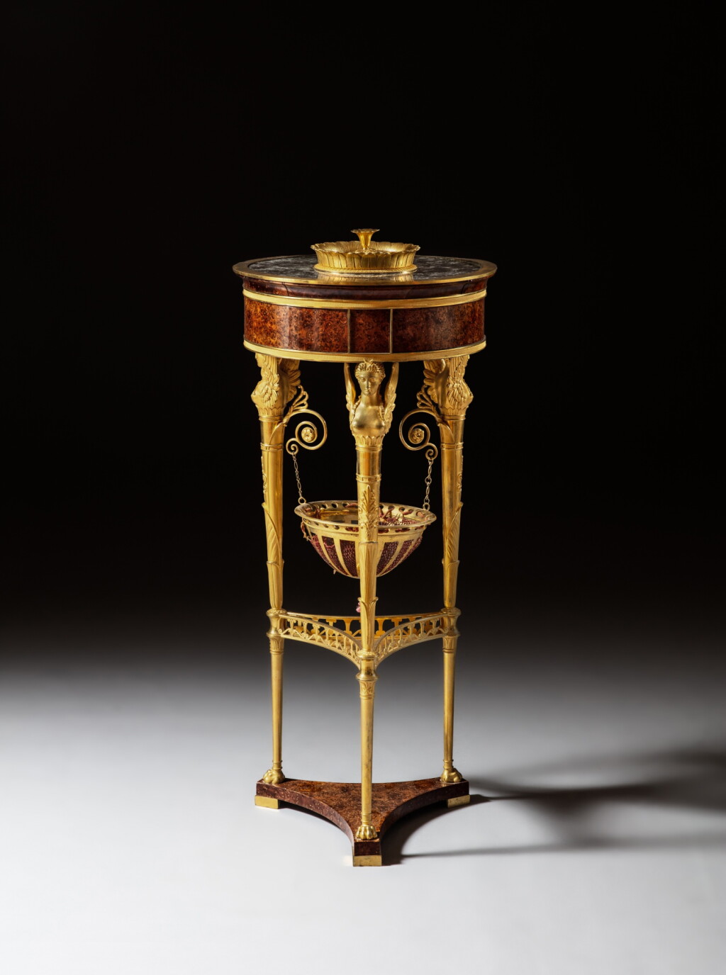 View full screen - View 1 of Lot 83. An Empire gilt-bronze mounted yew burl and mahogany veneered à cassolette table, circa 1810, by Jacob Frères.