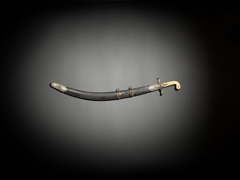 View full screen - View 1 of Lot 240. A walrus ivory-hilted sword with scabbard, 18th century, the mounts Persian, the blade and hilt Ottoman, the blade possibly earlier.