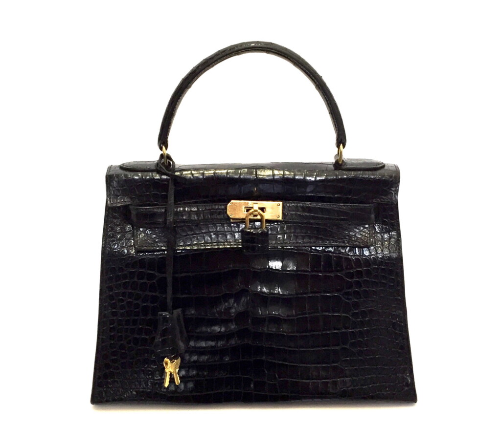 View full screen - View 1 of Lot 743. HERMÈS | BLACK KELLY 28 IN SHINY CROCODILE WITH GOLD HARDWARE, 1962.
