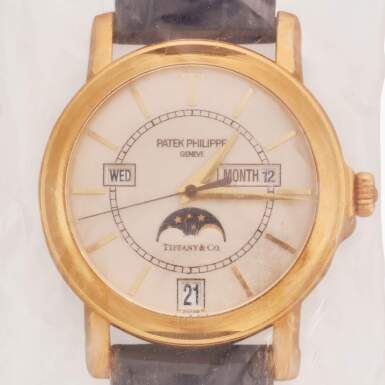 View full screen - View 1 of Lot 19. Retailed by Tiffany & Co.: Reference 5150 'T150' | A limited edition yellow gold automatic annual calendar wristwatch with moon phases and engraved case back, Made to commemorate the 150th anniversary of the exceptional relationship between Patek Philippe and Tiffany & Co., Single Sealed, Made in 2001.