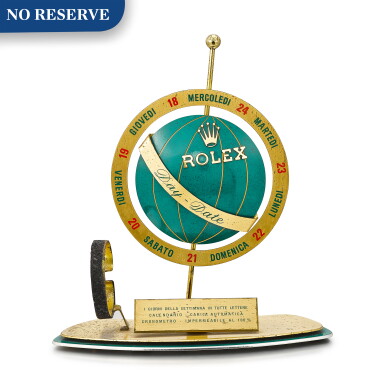 View full screen - View 1 of Lot 8070. ROLEX | DAY OF THE WEEK A GILT BRASS AND GREEN ENAMEL RETAILER'S WINDOW DISPLAY, CIRCA 1960.