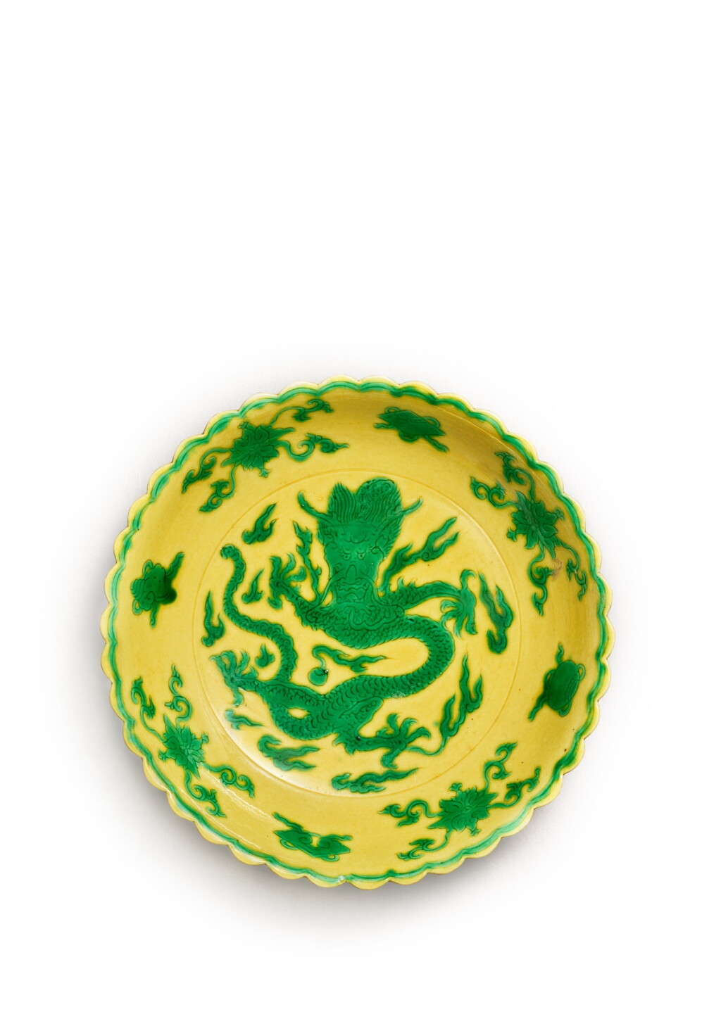 View full screen - View 1 of Lot 3694. A rare yellow-ground green-enamelled 'dragon' lobed dish, Mark and period of Kangxi | 清康熙 黃地綠彩刻龍紋花口盤 《大清康熙年製》款.