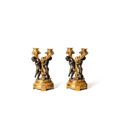 View full screen - View 1 of Lot 50. A pair of Louis XVI patinated and gilt-bronze two-light "putti" candelabra, circa 1770, after a model by Pierre Gouthière or Philippe Caffieri | Paire de candélabres aux putti à deux lumières en bronze doré et patiné d'époque Louis XVI, vers 1775, d'après un modèle de Pierre Gouthière ou Philippe Caffieri.