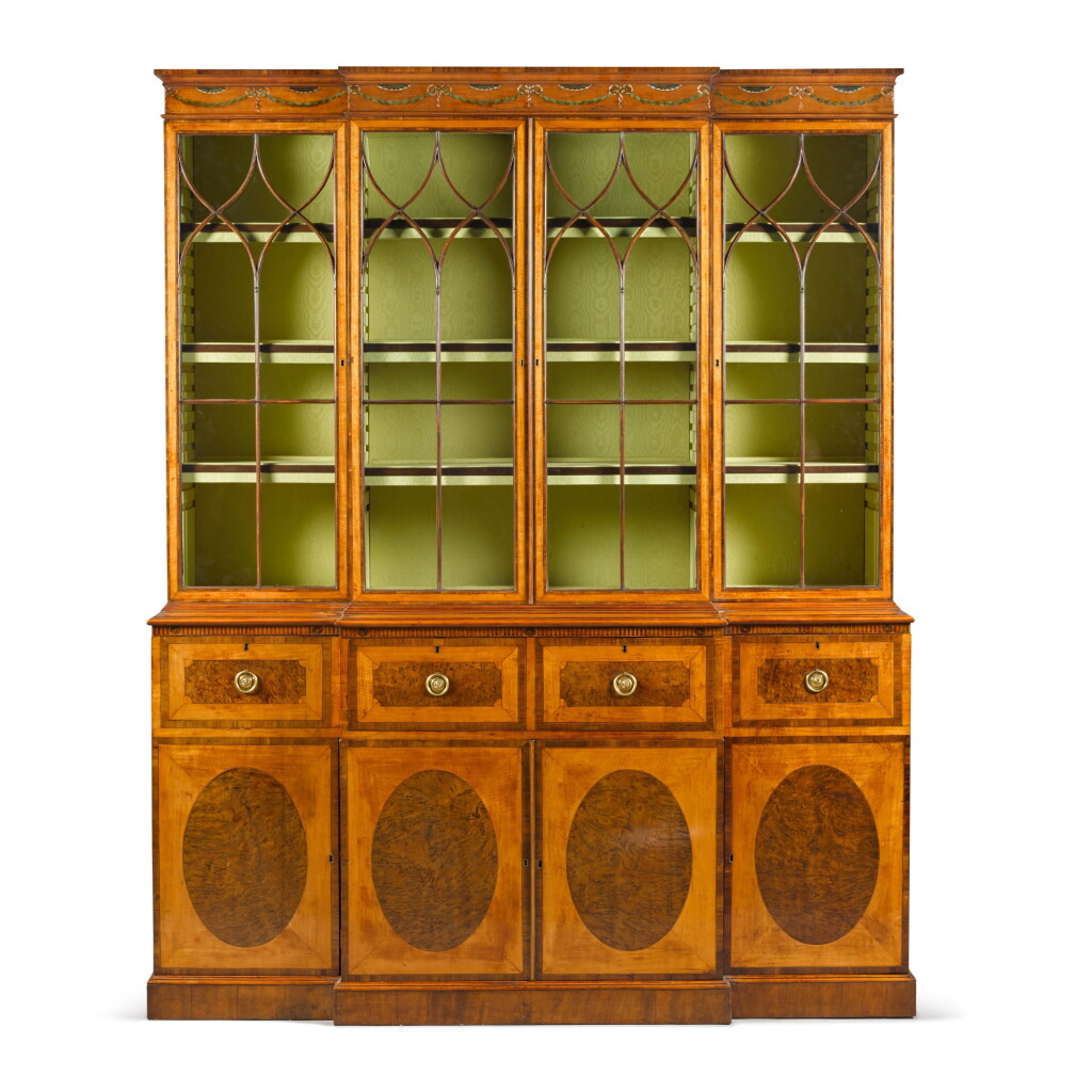 View full screen - View 1 of Lot 43. A George III mahogany, satinwood and burr walnut breakfront bookcase, in the manner of Mayhew & Ince, Circa 1775.