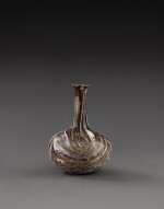 A Roman Marbled Aubergine Glass Bottle, circa 1st Century A.D.