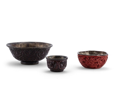 View full screen - View 1 of Lot 109. Deux bols en laque ‘tixi’ en laque rouge et noire Dynastie Ming et Qing | 明及清 烏面剔犀如意紋盌及剔紅花卉紋盌一組三件 | Two 'tixi' black lacquer bowls, Ming Dynasty; together with a carved cinnabar lacquer hexagonal 'flower' bowl, Qing Dynasty.