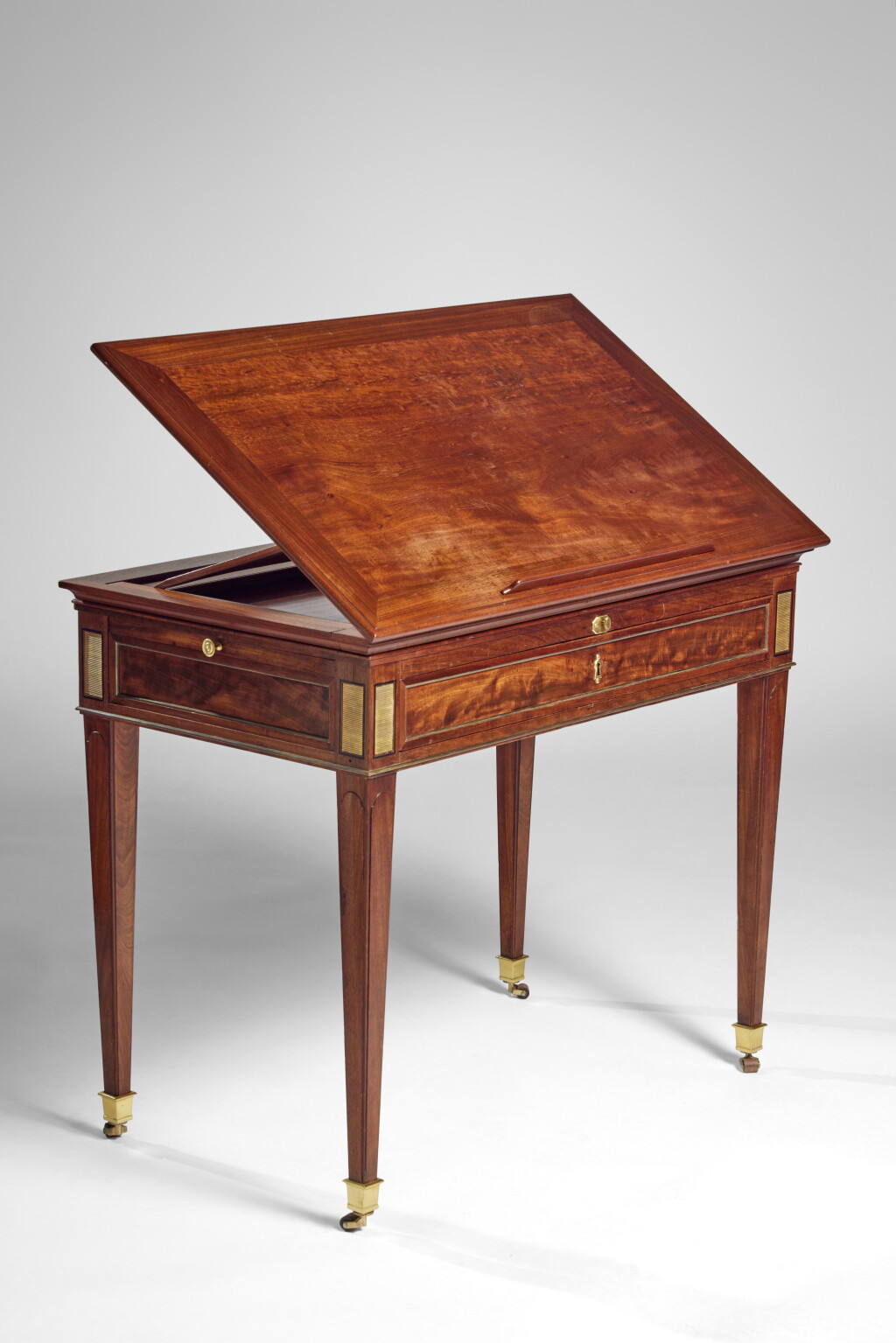 View full screen - View 1 of Lot 200. A Louis XVI Gilt Brass Mounted Mahogany and Ebony Table à la Tronchin by Jean-Henri Riesener, Circa 1785.