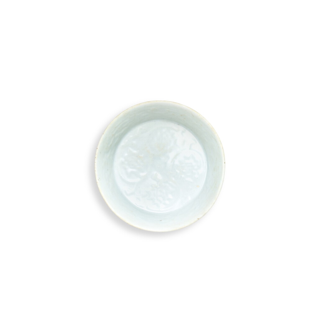 View full screen - View 1 of Lot 5841. A moulded shufu white-glazed 'flower' bowl, Yuan dynasty | 元 樞府白釉印花卉紋小盌.