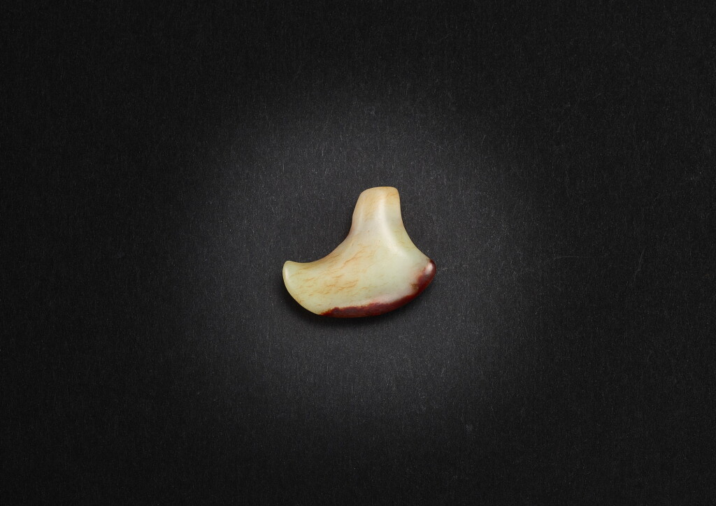 View full screen - View 1 of Lot 3854. A pale celadon and russet jade 'hook' pendant, Neolithic period, possibly Hongshan culture | 新石器時代 或紅山文化 青白玉勾形珮.
